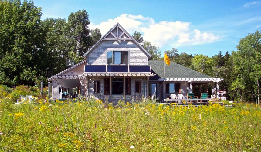 House in meadow with solar panels